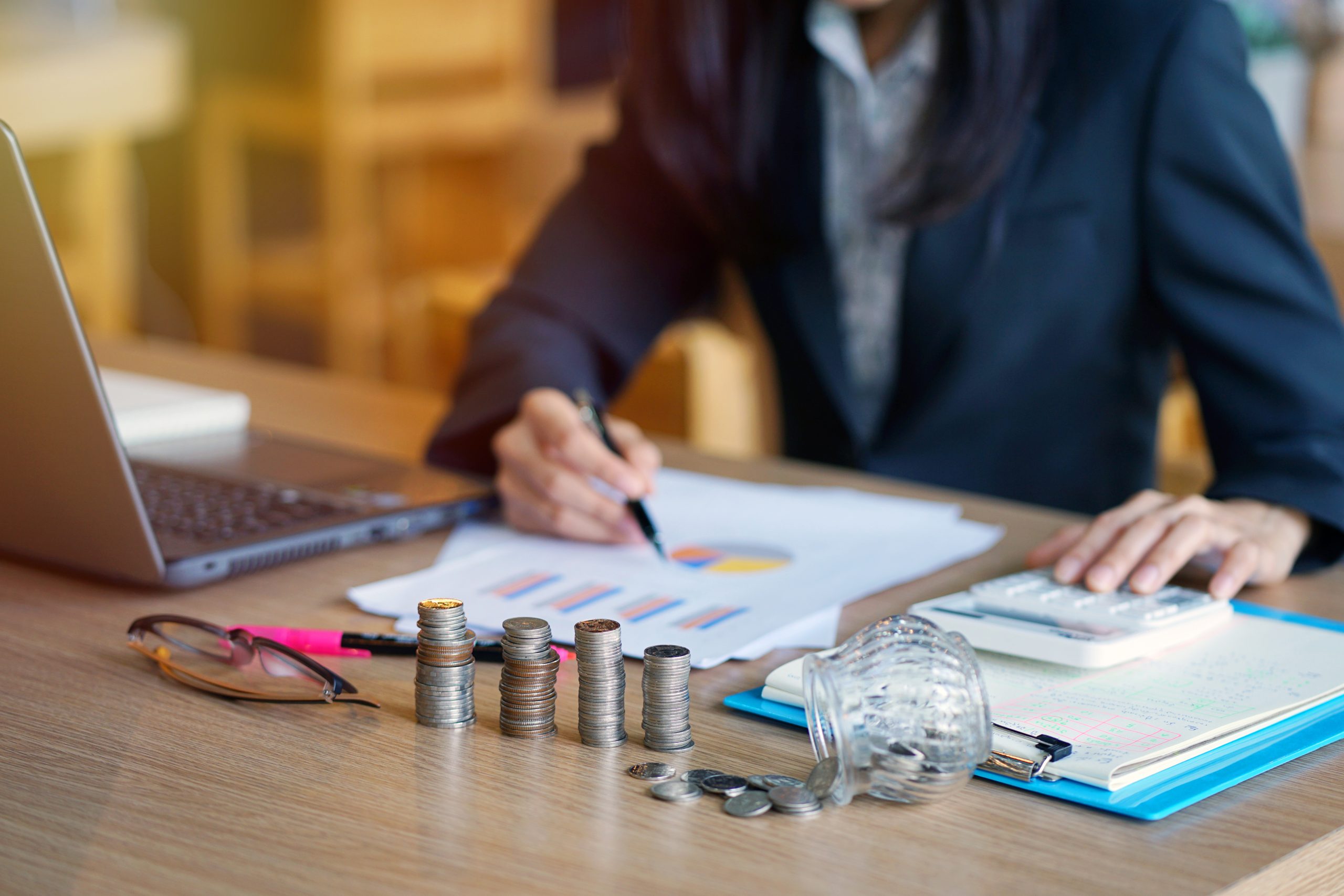 Analyse de trésorerie et planification financière avec SIMAX ERP no-code Personne analysant des graphiques financiers et calculant la trésorerie d’entreprise